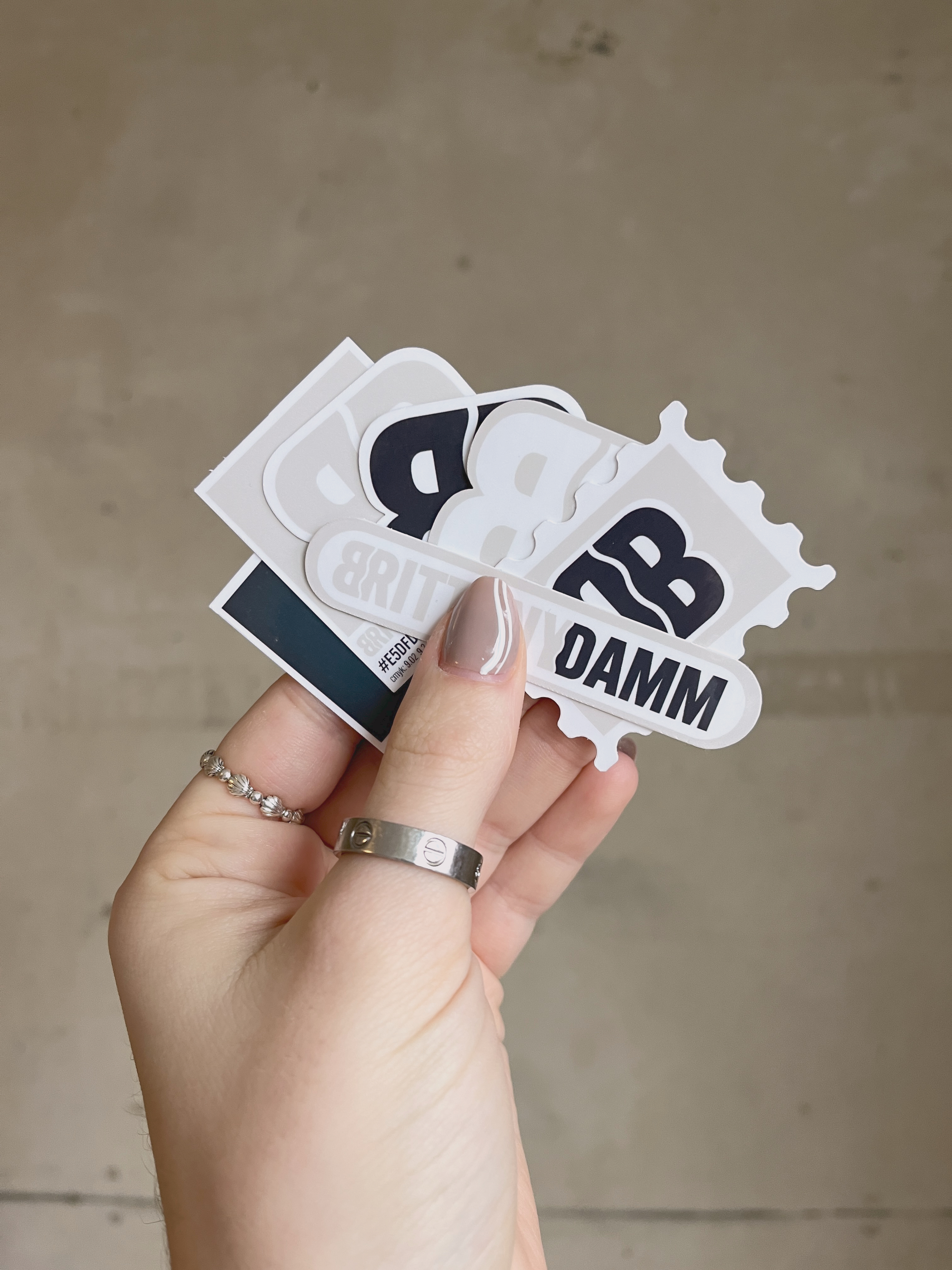 brand stickers held in hand, concrete wall background